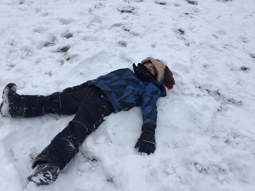 JKK boy making a snow angel