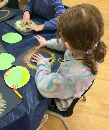 school-age girl making corona art with pastels