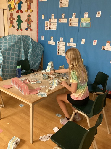 school-age girl building with cards