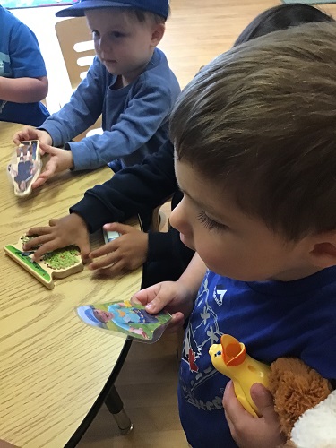 Toddler boys studying the blocks with pictures on them
