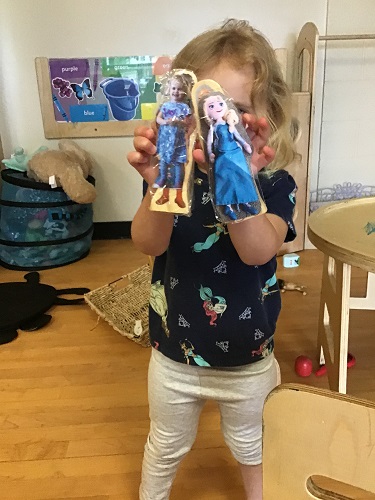 Toddler girl showing off block with her picture on it
