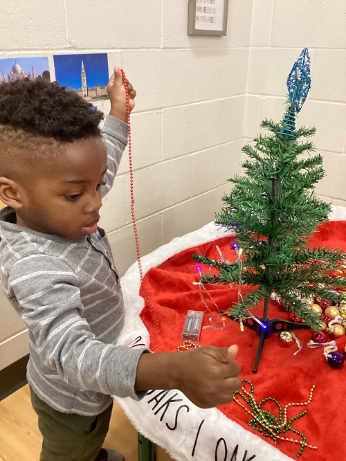 A child decorating their tree.