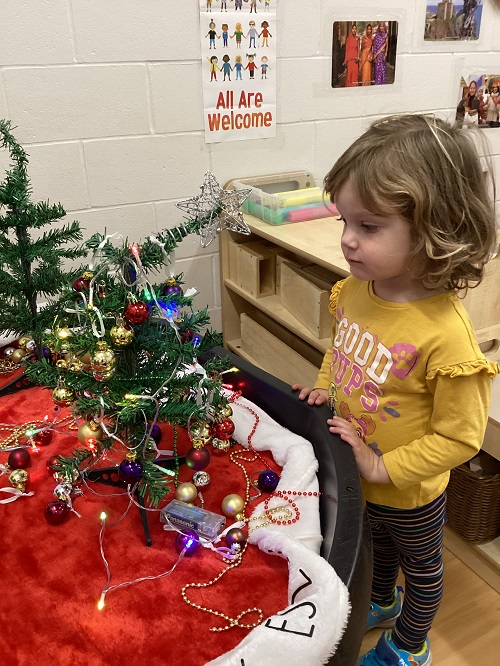 A child observing their decorated tree.