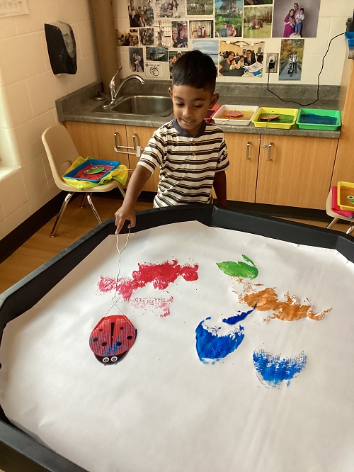 A child painting with a fly-swatter.