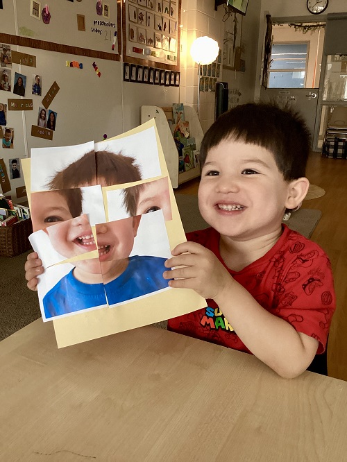 A child displaying their pasted together photo of themselves.