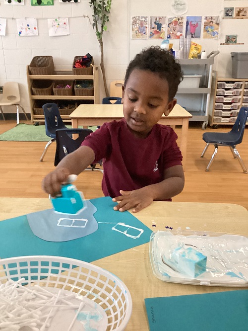 A child working on their artistic creation.