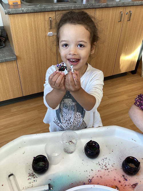 A child holding up loose parts.