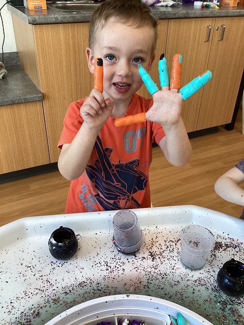 A child exploring with spooky themed fingers.