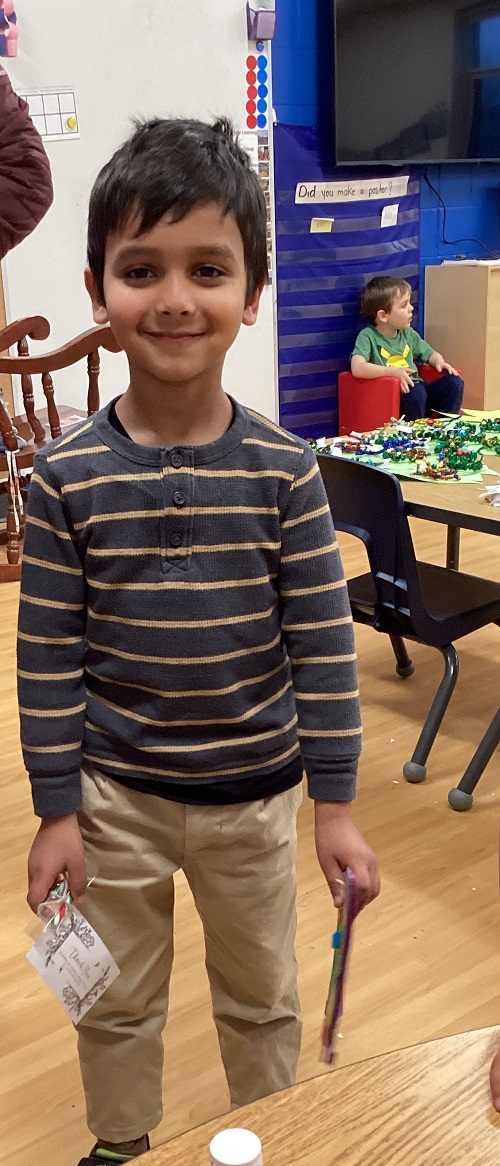 A child smiling while running their food drive.