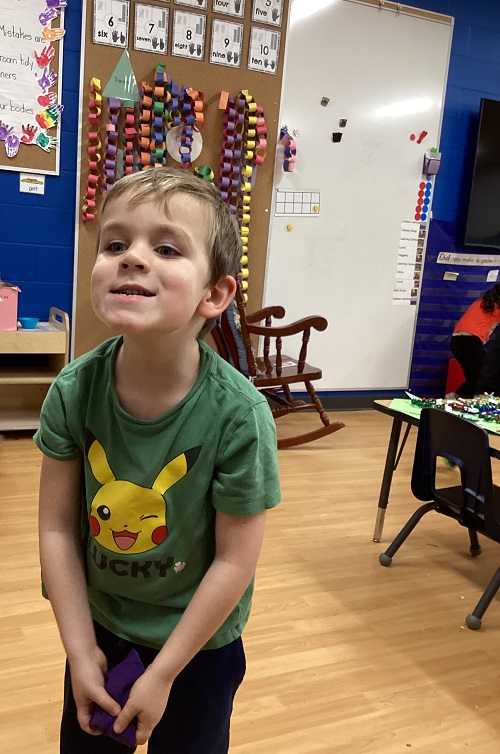 A child smiling while running their food drive.