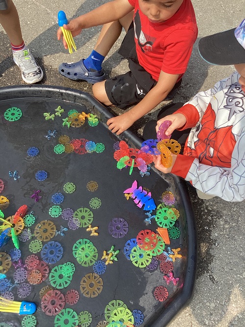 Children exploring colourful tile blocks in the tuff tray.