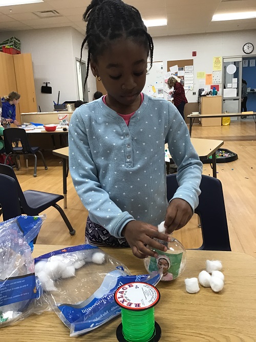 A child creating their tree ornament.