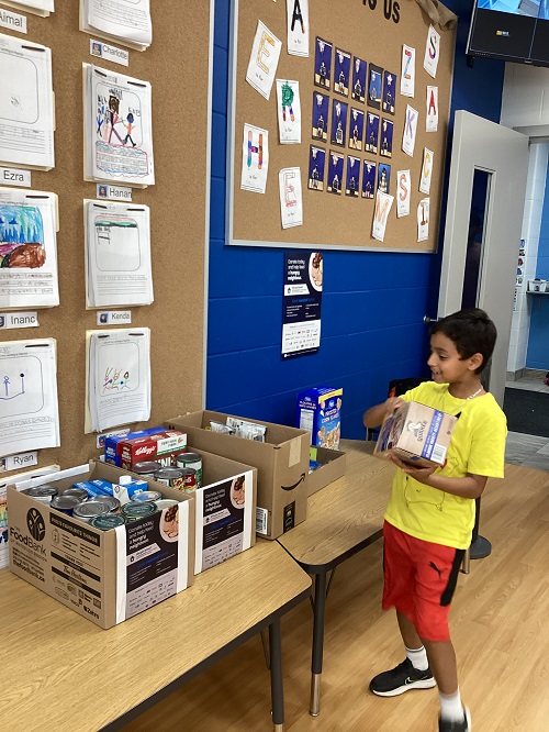 A child adding some donations for the Food Bank