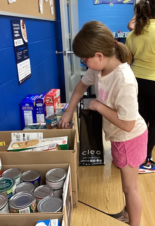 A child adding some donations for the Food Bank