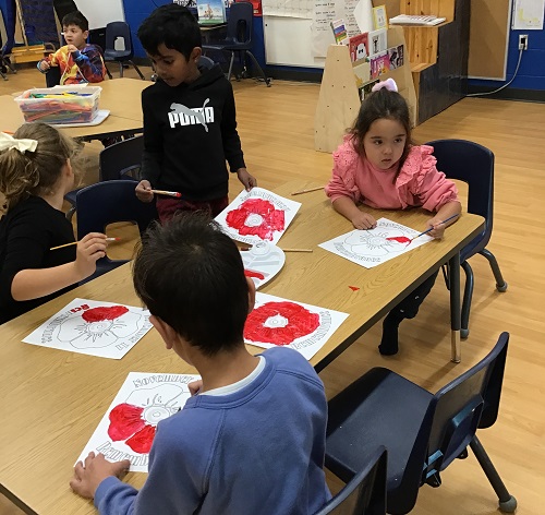 A small group of children creating poppies.