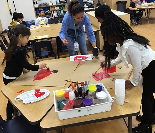 A small group of children creating poppies with an Educator.