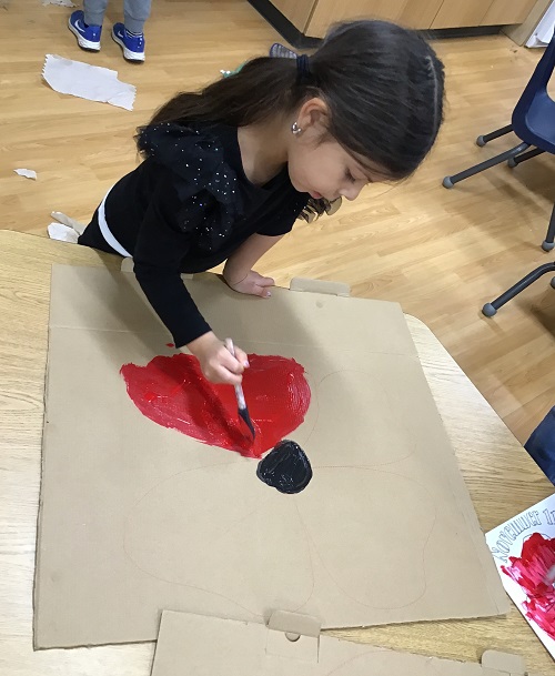 A child painting a poppy.