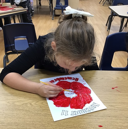 A child painting a poppy.