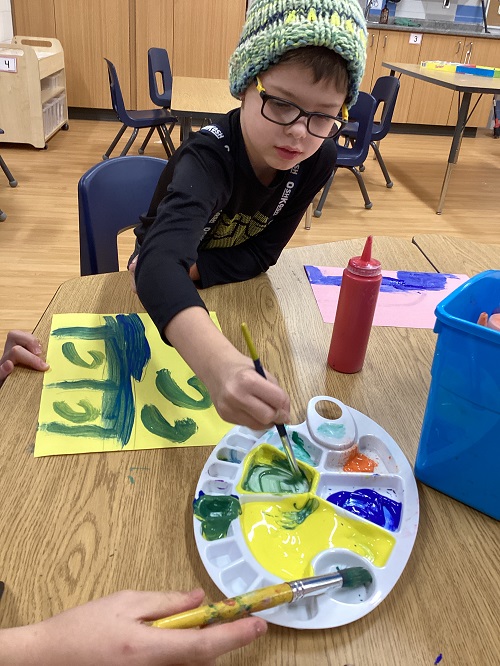 A child sitting at a table painting.