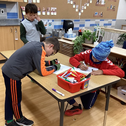 A small group of children drawing and colouring poppies.