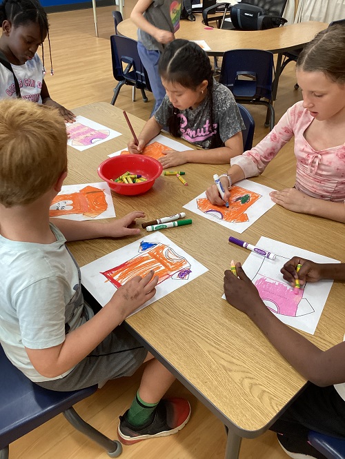 School age children working as a group colouring orange shirts