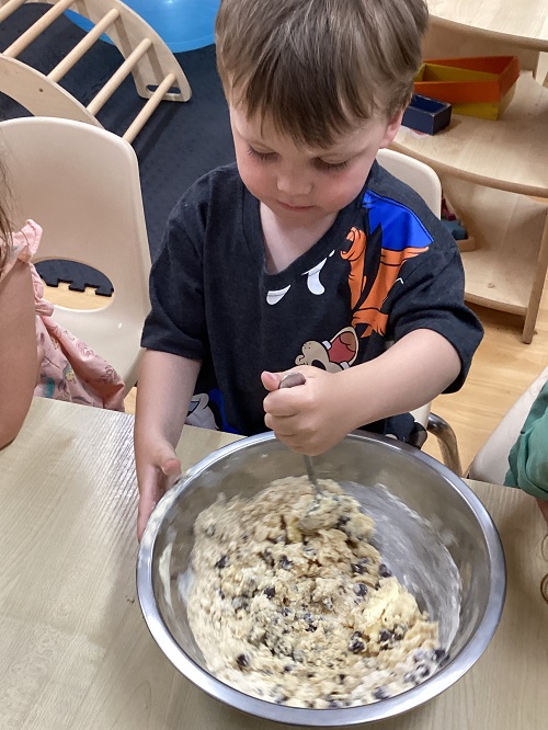 A preschool child mixing cookie dough