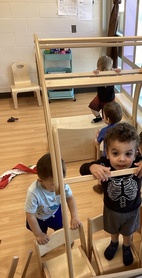 Children engaging in risky play in the toddler nook