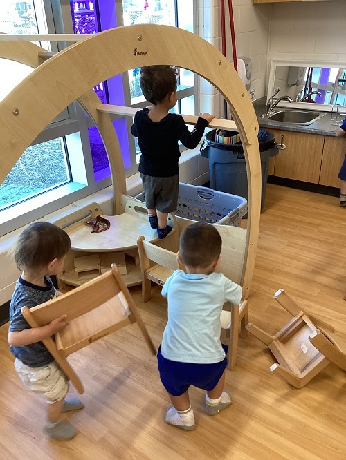 Children engaging in risky play in the toddler nook