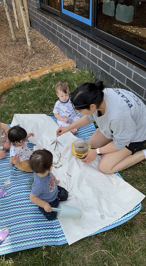 group of children and educator on a blanket