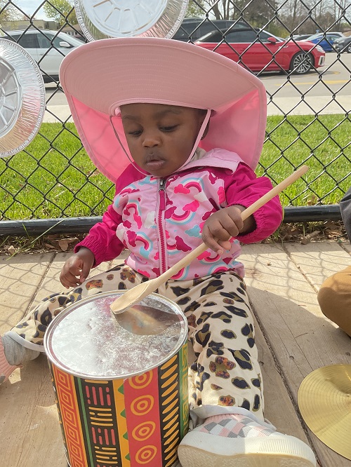 little girl banging the drum