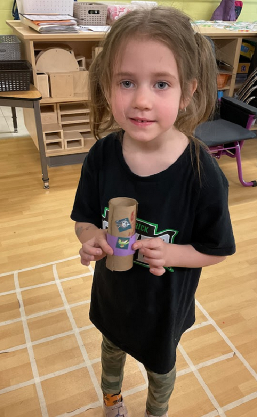 child with paper towel roll