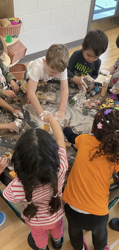 large group of children at the tuff tray