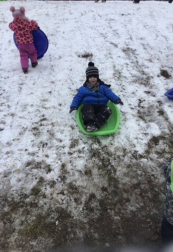 Child sledding down the hill