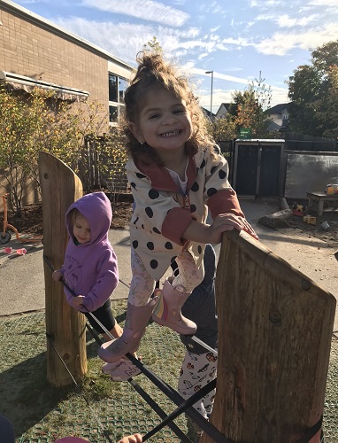 A child standing on ratchet straps around a pole