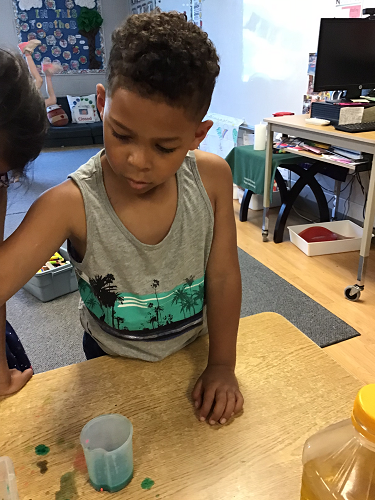 A child experimenting with coloured water and oil