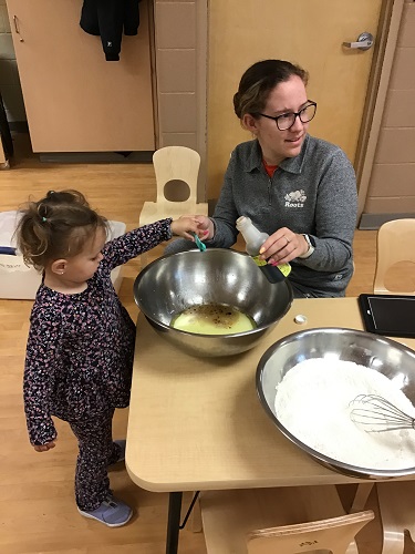 A child adding vanilla to a bowl for baking