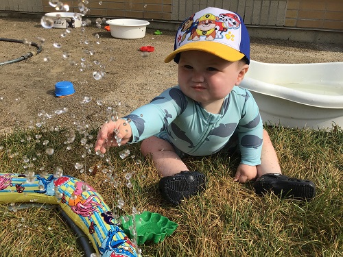 Infant holding hand in spraying water