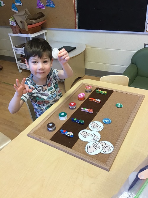 A child holding up three fingers and the number three card