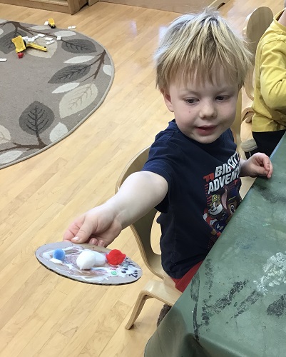 A child holding out their craft