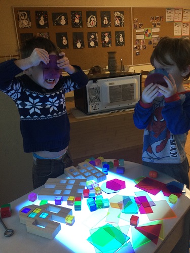 Children looking through coloured translutent shapes