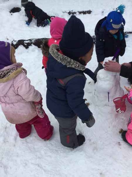 preschoolers building a snowman