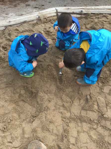 boys digging for worms with an ice cream scoop