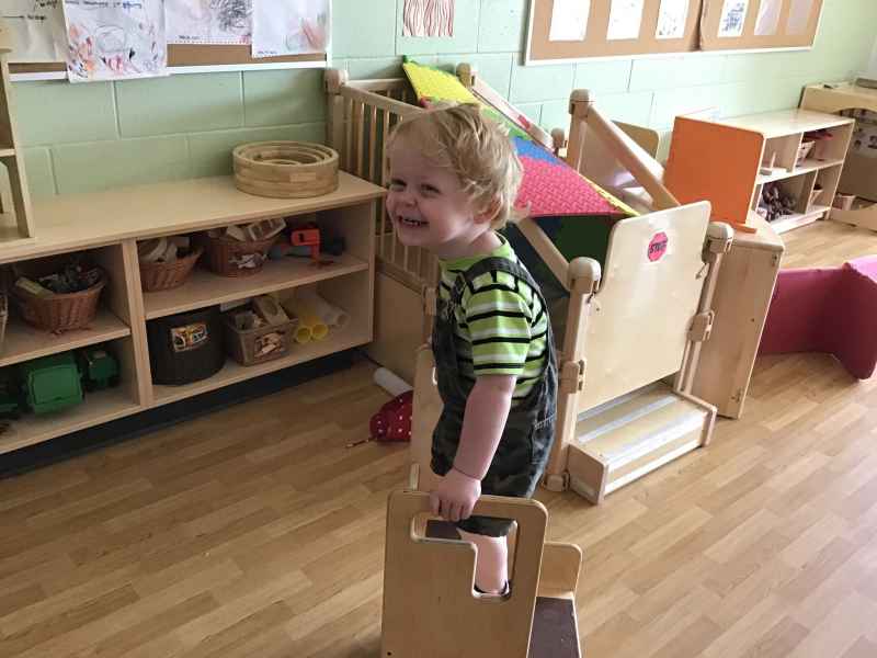 happy boy standing on a stool