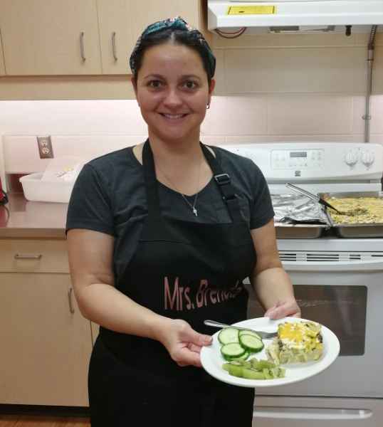 cook showing healthy food on a plate in the kitchen