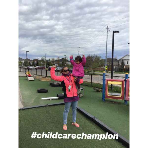 educator holding child with a flexed arm showing strength