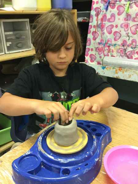 boy making a clay pot