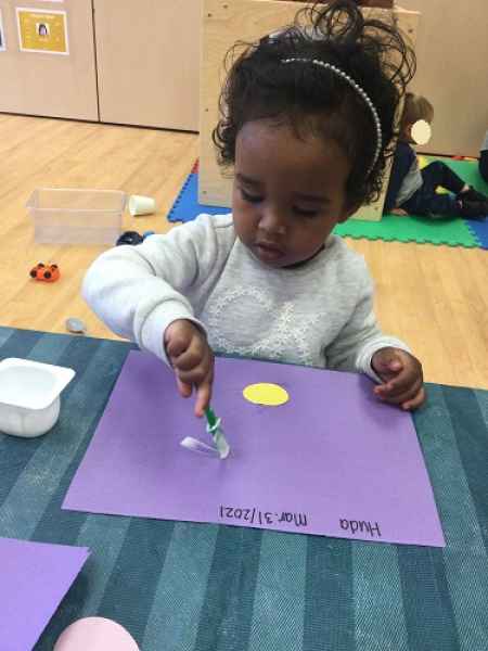 girl gluin shapes on a piece of paper