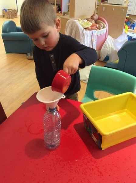 boy pouring water through a funnel