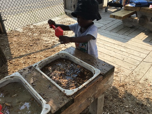 child at mud kitchen