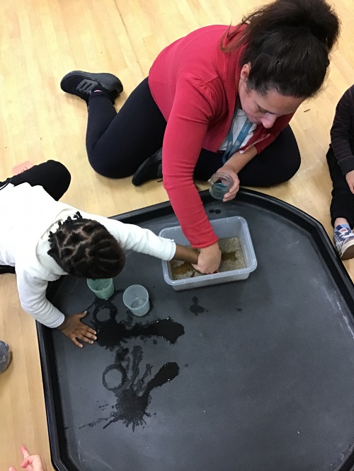 educator and child in a tuff tray